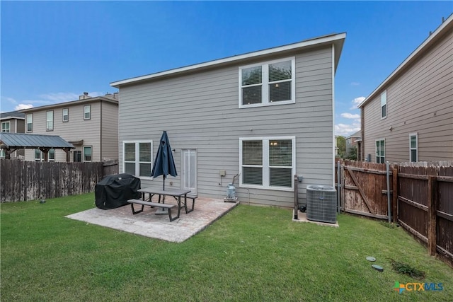 rear view of property featuring central air condition unit, a yard, and a patio