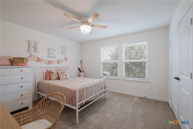 bedroom featuring a closet, light colored carpet, and ceiling fan