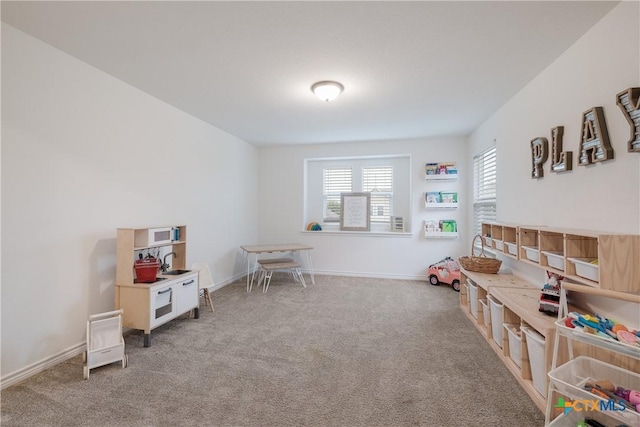 recreation room featuring light carpet