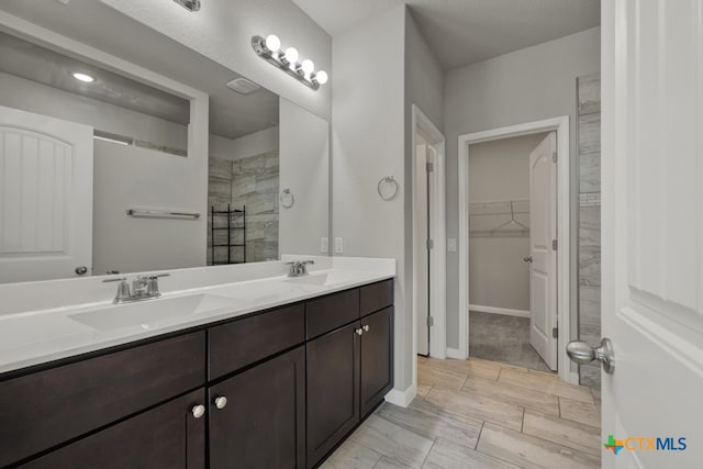 bathroom with vanity and tiled shower