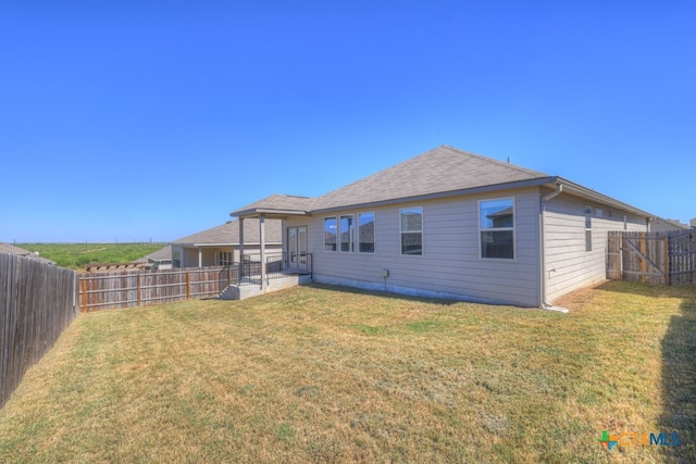 rear view of house with a yard