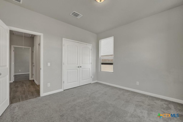 unfurnished bedroom with light colored carpet and a closet