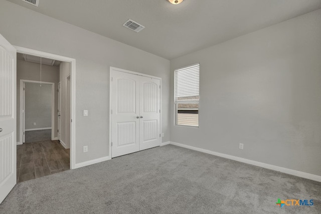 unfurnished bedroom featuring light carpet and a closet