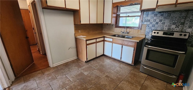 3605 Oaklawn St, Victoria, TX 77901 - kitchen featuring electric stove, under cabinet range hood, light countertops, and white cabinets