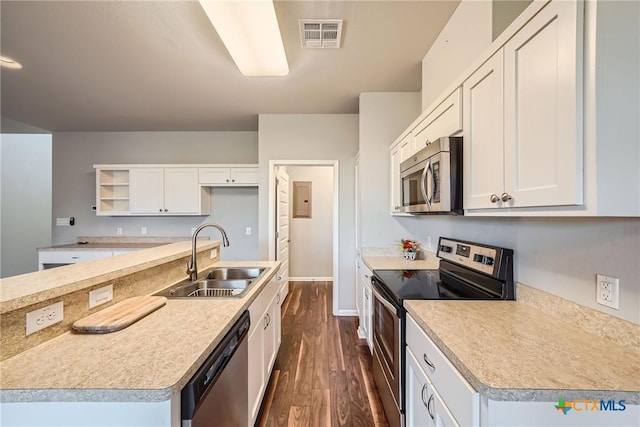 kitchen with sink, white cabinetry, stainless steel appliances, dark hardwood / wood-style floors, and an island with sink