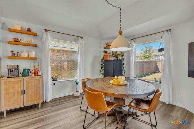 dining space featuring lofted ceiling and light wood-type flooring