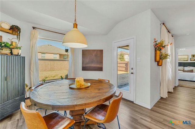 dining space featuring lofted ceiling and light hardwood / wood-style flooring