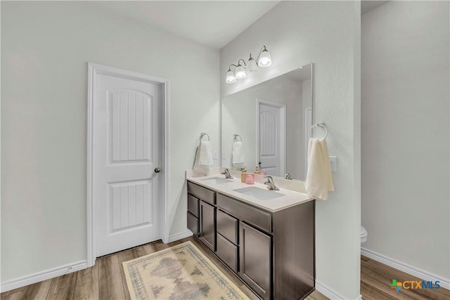 bathroom featuring wood-type flooring, vanity, and toilet