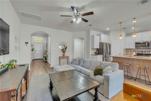 living room with light hardwood / wood-style floors and ceiling fan