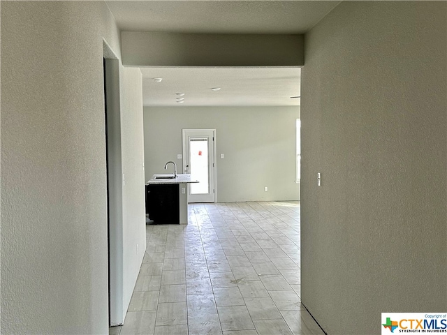 hallway with sink and light tile patterned floors