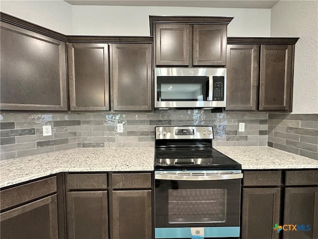 kitchen with stainless steel appliances, light stone countertops, dark brown cabinets, and backsplash