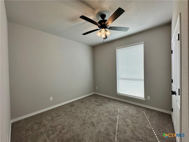 empty room with ceiling fan and dark colored carpet