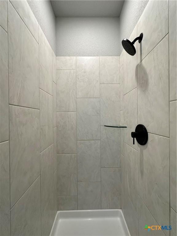 bathroom with tiled shower