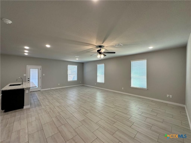 unfurnished room with sink and ceiling fan