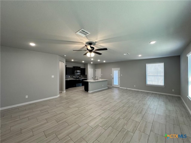 unfurnished living room with sink and ceiling fan