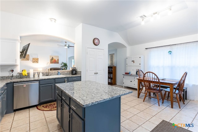 kitchen with a kitchen island, white cabinetry, vaulted ceiling, stainless steel dishwasher, and ceiling fan