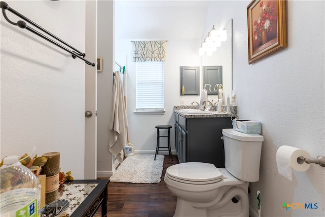 bathroom with hardwood / wood-style flooring, vanity, and toilet