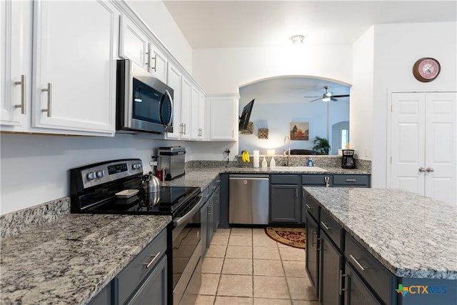 kitchen featuring sink, light tile patterned floors, ceiling fan, white cabinetry, and appliances with stainless steel finishes