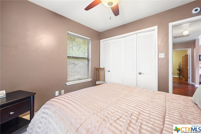 bedroom with wood-type flooring, ceiling fan, and a closet