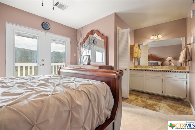 bedroom featuring access to exterior, french doors, and sink