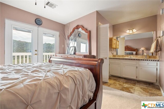 350 Climbing Way, Wimberley, TX 78676 - bedroom featuring french doors, access to exterior, ensuite bathroom, light colored carpet, and a sink