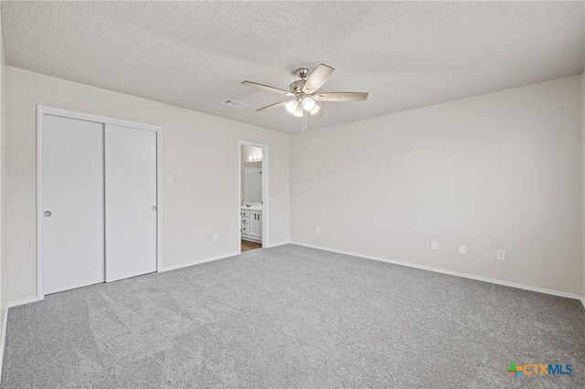 unfurnished bedroom with a ceiling fan, visible vents, carpet floors, a closet, and a textured ceiling