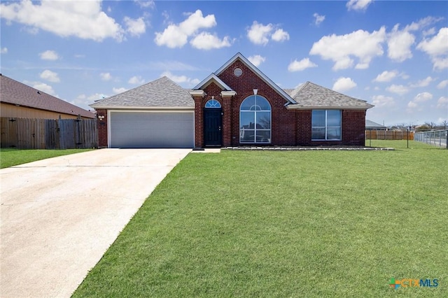 view of front of home with brick siding, a front yard, and fence