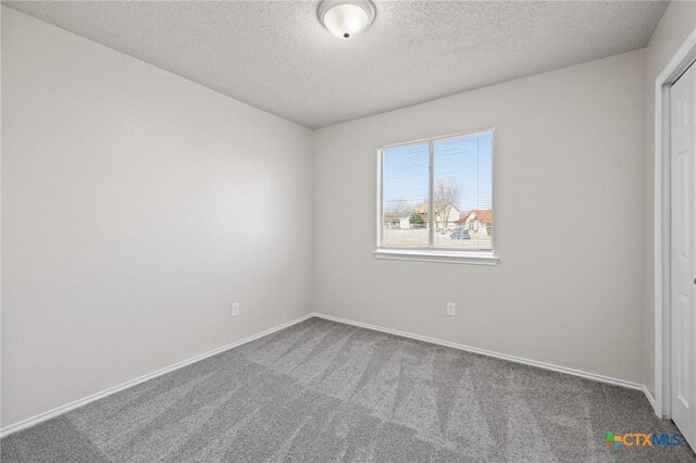 unfurnished bedroom featuring carpet, baseboards, and a textured ceiling