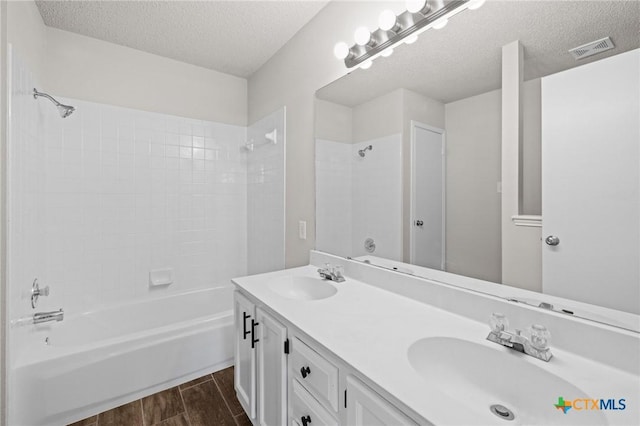 bathroom with a sink, visible vents, shower / washtub combination, and wood tiled floor