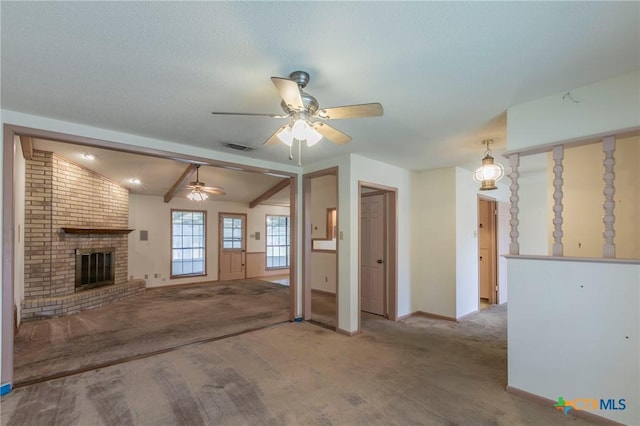 unfurnished living room with lofted ceiling, ceiling fan, a fireplace, visible vents, and carpet