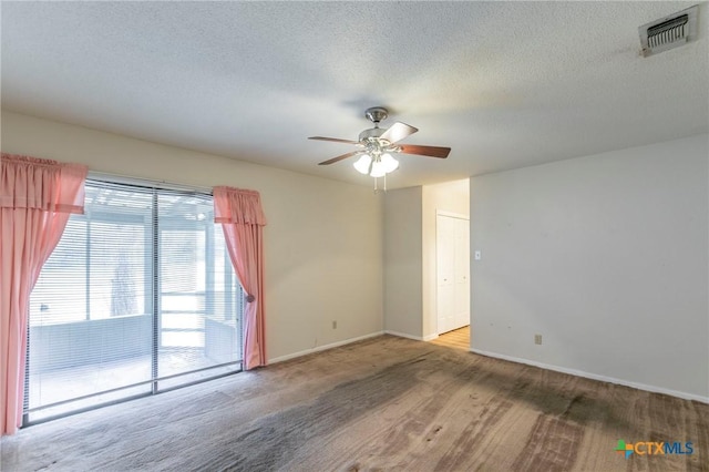 spare room with ceiling fan, a textured ceiling, visible vents, and baseboards