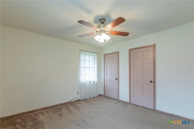 unfurnished bedroom featuring baseboards, ceiling fan, and light colored carpet