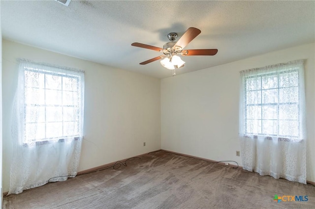 unfurnished room featuring a textured ceiling, carpet flooring, and a ceiling fan