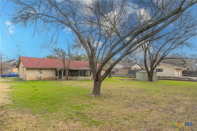 view of yard featuring an outbuilding, fence, and a storage unit