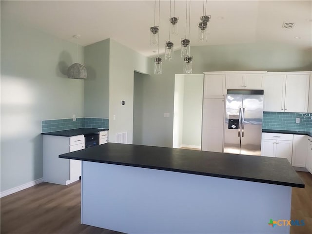 1211 W Houson Ave, Seadrift, TX 77983 - kitchen featuring dark countertops, tasteful backsplash, dark wood finished floors, stainless steel refrigerator with ice dispenser, and white cabinets