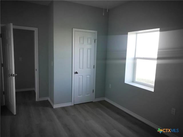 1211 W Houson Ave, Seadrift, TX 77983 - unfurnished bedroom featuring baseboards and wood finished floors