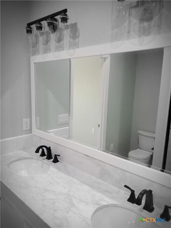 1211 W Houson Ave, Seadrift, TX 77983 - full bathroom with double vanity, toilet, and a sink