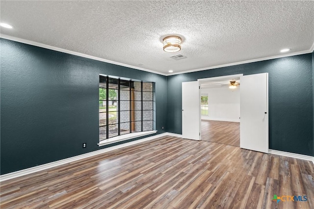 4101 Briar Cliff Rd, Temple, TX 76502 - empty room with wood finished floors, a textured ceiling, a textured wall, ornamental molding, and recessed lighting