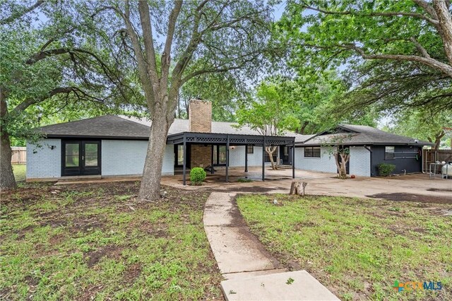 4101 Briar Cliff Rd, Temple, TX 76502 - view of front of house featuring a chimney, french doors, brick siding, and a patio area