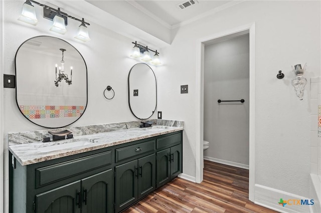 4101 Briar Cliff Rd, Temple, TX 76502 - bathroom featuring double vanity, ornamental molding, and wood finished floors
