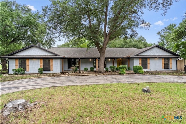 4101 Briar Cliff Rd, Temple, TX 76502 - ranch-style home with curved driveway, a front yard, and brick siding