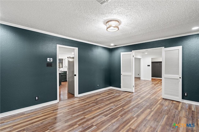 4101 Briar Cliff Rd, Temple, TX 76502 - spare room with a textured wall, a textured ceiling, wood finished floors, and crown molding