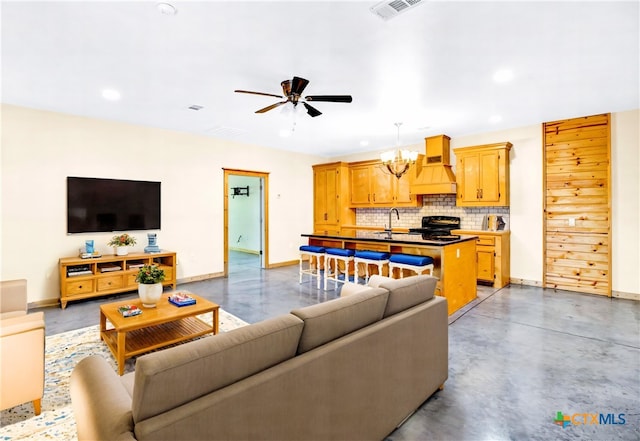 living room with ceiling fan with notable chandelier and sink