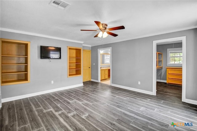 unfurnished living room featuring built in shelves, ceiling fan, crown molding, and dark wood-type flooring