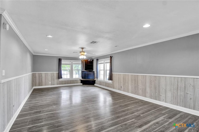 unfurnished living room featuring ceiling fan, crown molding, and dark wood-type flooring