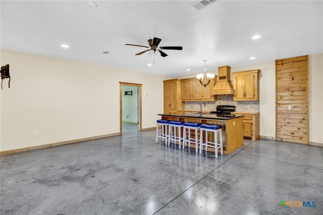 kitchen with pendant lighting, custom exhaust hood, a kitchen island with sink, black stove, and a breakfast bar area