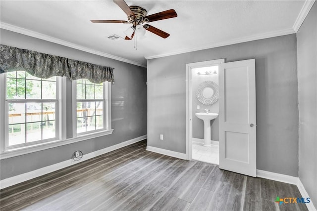 interior space featuring wood-type flooring, ensuite bath, ceiling fan, and crown molding