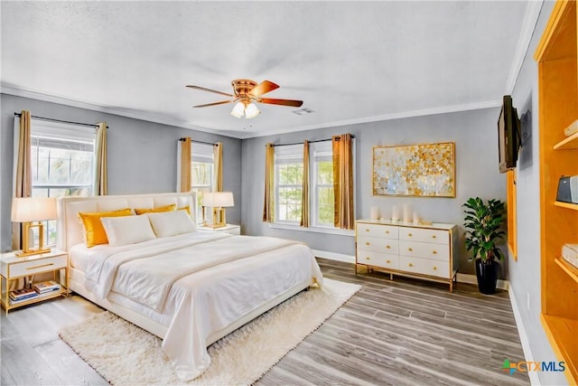 bedroom with wood-type flooring, ceiling fan, and crown molding