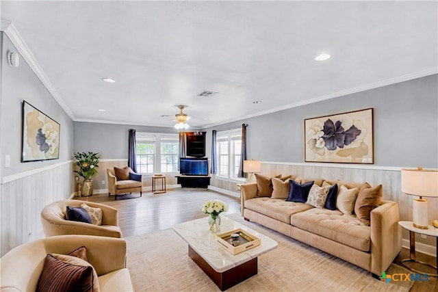 living room with light hardwood / wood-style flooring, ceiling fan, and crown molding