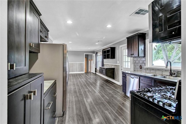 kitchen with dark wood-type flooring, sink, ornamental molding, dark brown cabinetry, and stainless steel appliances